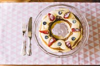 Overheerljke cake van biscuitdeeg met banketbakkersroom en verse rode vruchten Overheerljke cake van biscuitdeeg met banketbakkersroom en verse rode vruchten